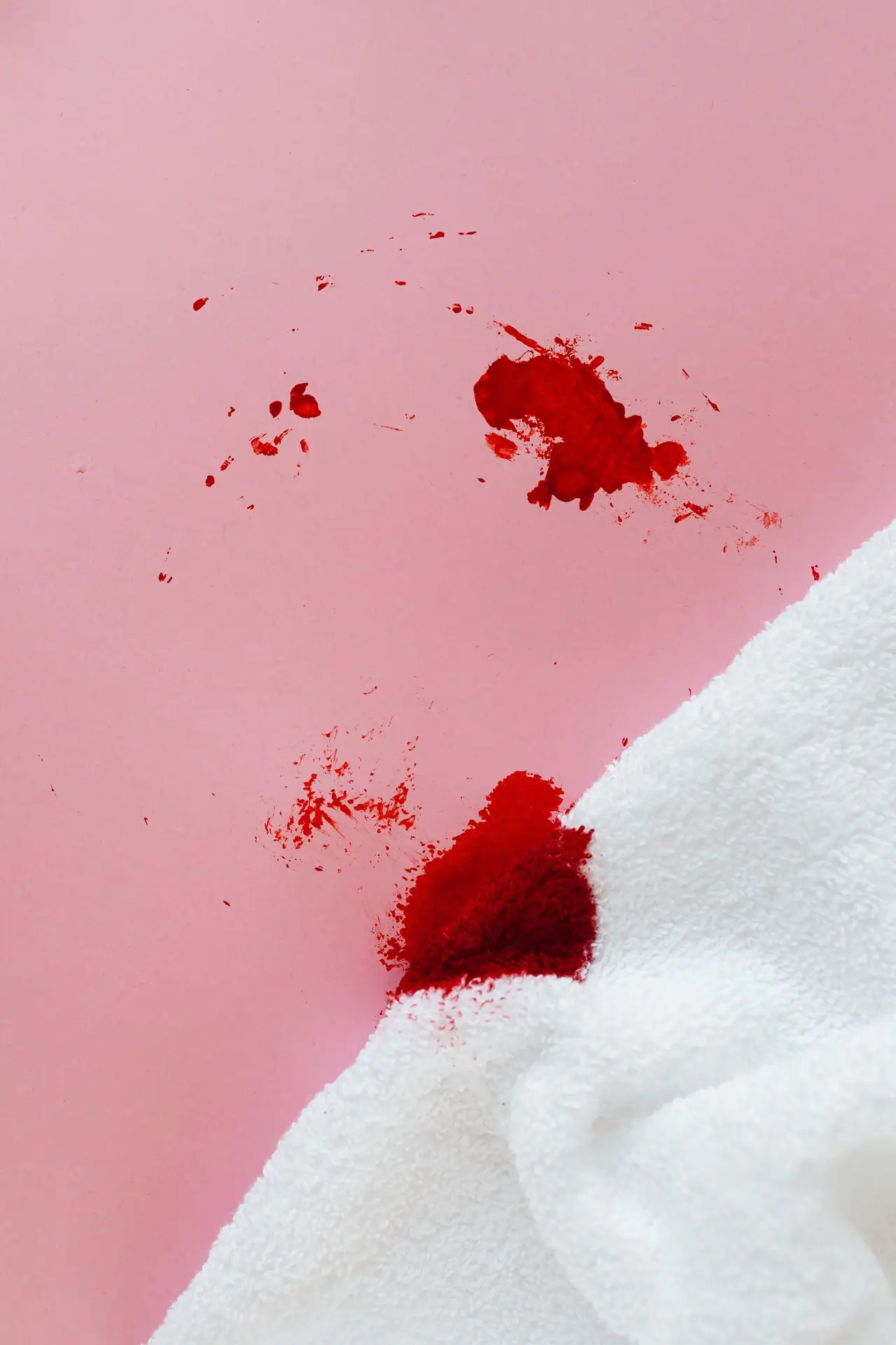 Red spill soaking into light carpet fibre, the moment that decides whether a stain is removable