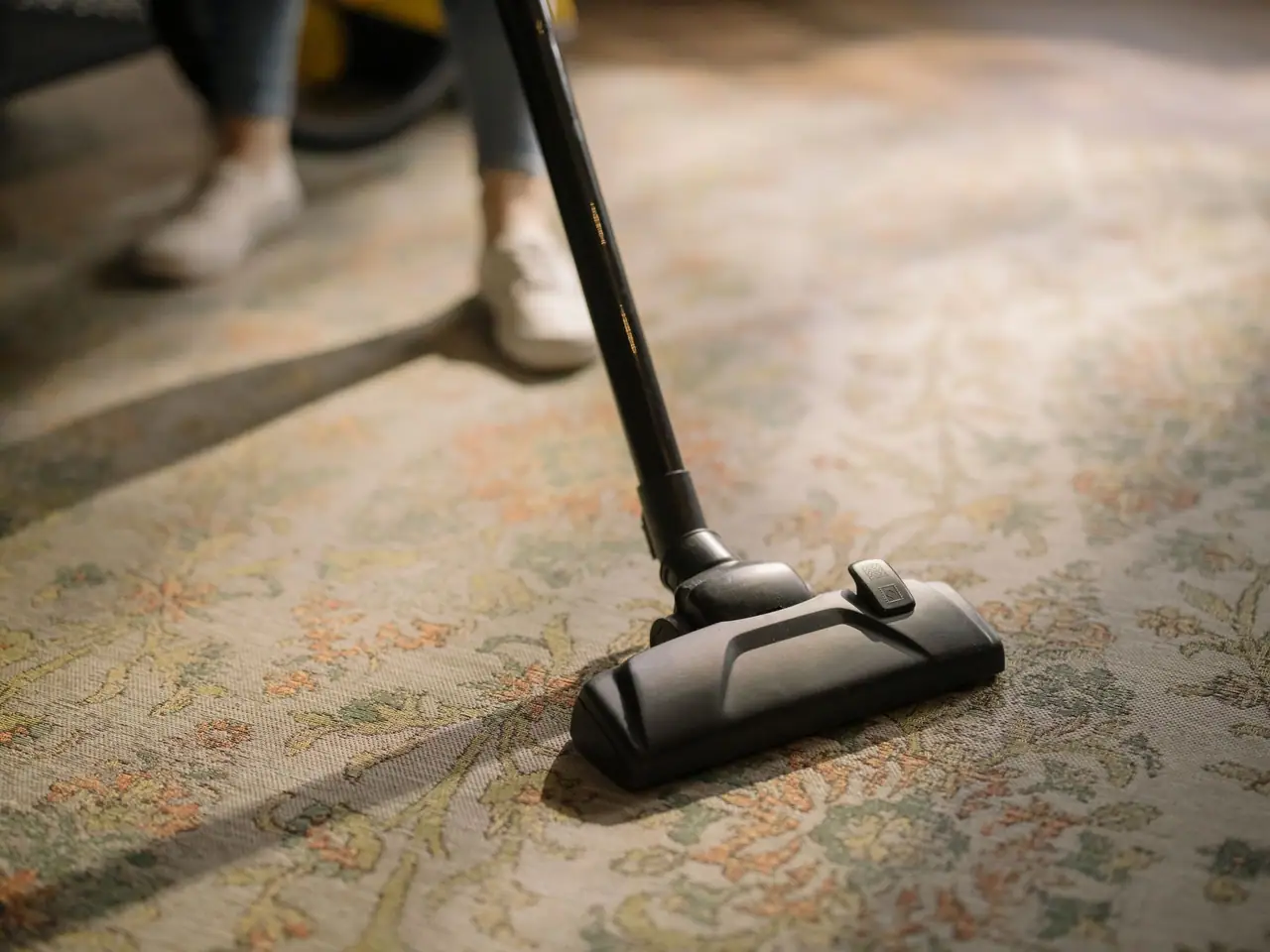Vacuuming carpet in a Seattle, WA home as part of the routine maintenance interval